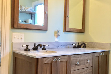 Modelo de cuarto de baño tradicional con armarios estilo shaker, puertas de armario de madera en tonos medios, encimera de mármol y encimeras grises