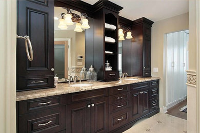 Inspiration for a mid-sized timeless master beige tile bathroom remodel in Orange County with an undermount sink, raised-panel cabinets, dark wood cabinets, granite countertops and beige walls
