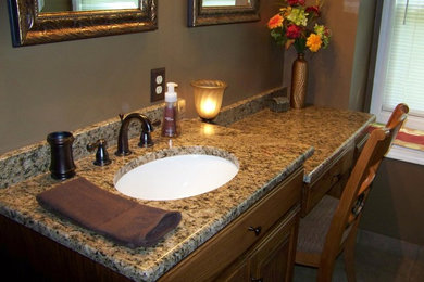 Bathroom - mid-sized traditional master ceramic tile bathroom idea in Other with raised-panel cabinets, medium tone wood cabinets, brown walls, an undermount sink and granite countertops