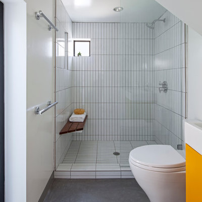 Small trendy master white tile and ceramic tile concrete floor and gray floor bathroom photo in Los Angeles with flat-panel cabinets, a one-piece toilet, white walls, a console sink, orange cabinets, quartz countertops and white countertops