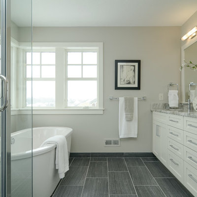 Freestanding bathtub - cottage gray tile freestanding bathtub idea in Minneapolis with shaker cabinets and white cabinets