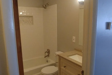 Aménagement d'une salle de bain contemporaine de taille moyenne pour enfant avec un placard à porte shaker, des portes de placard blanches, un carrelage gris, un carrelage métro, un mur gris, un sol en marbre, un plan de toilette en granite et un sol multicolore.
