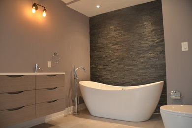 Diseño de cuarto de baño principal moderno grande con armarios con paneles lisos, puertas de armario marrones, bañera exenta, paredes grises y lavabo bajoencimera