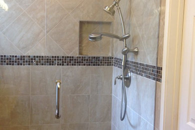 Example of a small classic master beige tile and porcelain tile porcelain tile corner shower design in Orange County with shaker cabinets, brown cabinets, a one-piece toilet, beige walls, an undermount sink and granite countertops