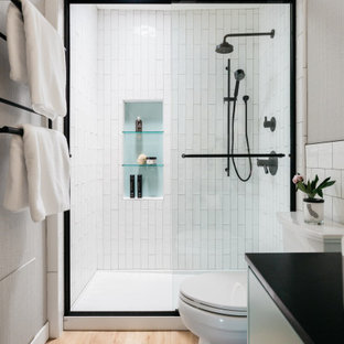 Idee per una piccola stanza da bagno con doccia minimal con ante lisce, ante turchesi, doccia alcova, WC a due pezzi, piastrelle bianche, piastrelle in gres porcellanato, pareti bianche, pavimento in vinile, lavabo a bacinella, top in granito, porta doccia scorrevole, top nero, nicchia, un lavabo, mobile bagno sospeso e carta da parati