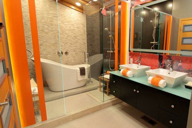 Bathroom - mid-sized contemporary master gray tile and stone tile concrete floor and gray floor bathroom idea in Minneapolis with flat-panel cabinets, black cabinets, glass countertops, orange walls, a vessel sink, a hinged shower door and green countertops