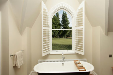 Imagen de cuarto de baño principal tradicional de tamaño medio con bañera con patas y paredes beige
