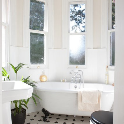 Small elegant claw-foot bathtub photo in Surrey with pink walls