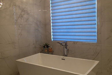 Elegant master white tile porcelain tile freestanding bathtub photo in Calgary with white walls