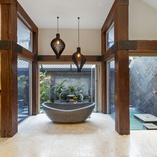 Asiatisches Badezimmer En Suite mit freistehender Badewanne, offener Dusche, Wandtoilette, farbigen Fliesen, Steinfliesen, bunten Wänden, Travertin, Sockelwaschbecken, Waschtisch aus Holz, buntem Boden und brauner Waschtischplatte in Sunshine Coast