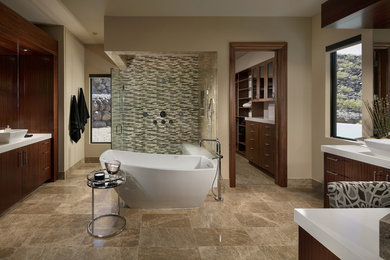Inspiration for a southwestern brown floor freestanding bathtub remodel in Las Vegas with flat-panel cabinets, dark wood cabinets, beige walls, a vessel sink, a hinged shower door and white countertops