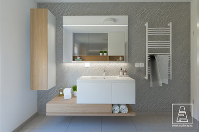 Modelo de cuarto de baño minimalista con sanitario de pared, paredes grises, suelo de baldosas de cerámica, aseo y ducha, lavabo encastrado, suelo gris y ducha abierta
