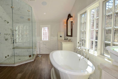 Foto de cuarto de baño principal tradicional renovado grande con armarios con rebordes decorativos, puertas de armario blancas, bañera exenta, ducha esquinera, paredes blancas y encimera de mármol