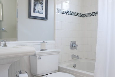 Imagen de cuarto de baño tradicional de tamaño medio con baldosas y/o azulejos en mosaico, lavabo con pedestal, bañera empotrada, combinación de ducha y bañera, sanitario de dos piezas, suelo de baldosas de cerámica, paredes grises y ducha con cortina