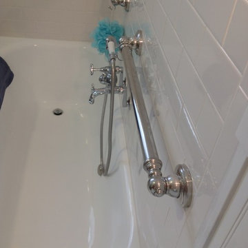 Vintage style tub with a hand held shower and decorative grab bars with waterpro