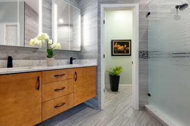 Inspiration for a mid-sized modern master gray tile and porcelain tile porcelain tile, gray floor and double-sink bathroom remodel in Jacksonville with flat-panel cabinets, light wood cabinets, a one-piece toilet, green walls, an undermount sink, quartz countertops, white countertops and a floating vanity