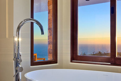 Diseño de cuarto de baño contemporáneo de tamaño medio con bañera exenta, suelo de baldosas de cerámica y paredes beige