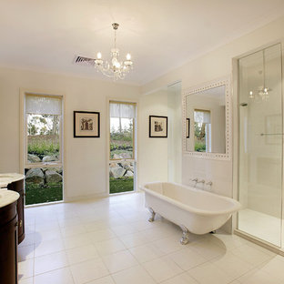This is an example of a transitional master bathroom in Other with recessed-panel cabinets, dark wood cabinets, a claw-foot tub, an alcove shower, white tile, white walls, an undermount sink, white floor, an open shower and white benchtops.