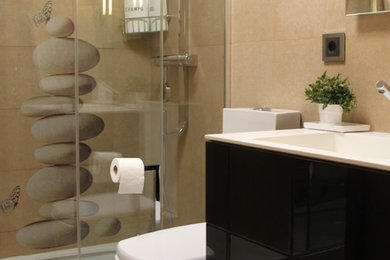 他の地域にあるお手頃価格の中くらいなコンテンポラリースタイルのおしゃれなバスルーム (浴槽なし) (フラットパネル扉のキャビネット、黒いキャビネット、アルコーブ型シャワー、分離型トイレ、ベージュの壁、セラミックタイルの床、一体型シンク) の写真