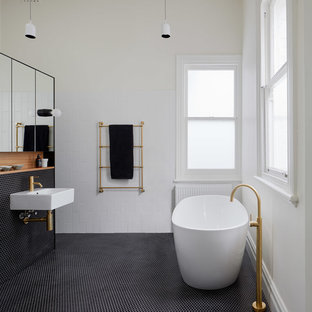 Inspiration for a small contemporary bathroom in Melbourne with a freestanding tub, white tile, white walls, mosaic tile floors and black floor.