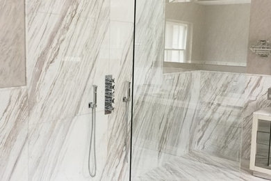 This is an example of a large contemporary family bathroom in London with white cabinets, a walk-in shower, white tiles, marble tiles, white walls, marble flooring, marble worktops and white floors.