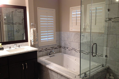 This is an example of a contemporary bathroom in Orange County with dark wood cabinets, a corner bath, a corner shower, a one-piece toilet and a built-in sink.