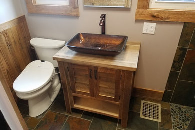 Small mountain style 3/4 multicolored tile and slate tile slate floor and multicolored floor bathroom photo in Cincinnati with louvered cabinets, light wood cabinets, a bidet, beige walls, a vessel sink and wood countertops