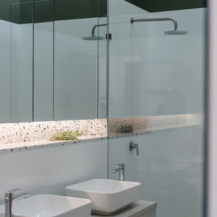 Inspiration for a small contemporary master bathroom in Other with grey cabinets, a wall-mount toilet, white tile, stone tile, white walls, porcelain floors, a vessel sink, laminate benchtops, beige floor, an open shower, grey benchtops, a floating vanity, vaulted, a niche, flat-panel cabinets, an alcove shower and a double vanity.