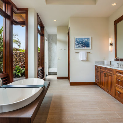 Inspiration for a tropical porcelain tile and beige floor freestanding bathtub remodel in Hawaii with shaker cabinets, medium tone wood cabinets, beige walls, an undermount sink and quartzite countertops