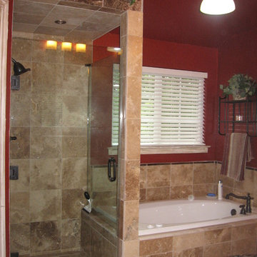 Walk in shower with frameless shower door, and travertine tile