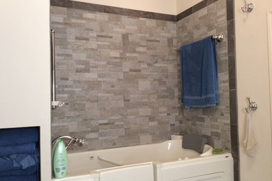 Mid-sized elegant gray tile and stone tile porcelain tile and brown floor bathroom photo in Miami with beige walls