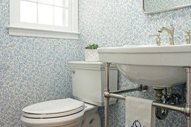 Foto de cuarto de baño único clásico con sanitario de dos piezas, paredes azules, suelo de madera oscura, lavabo tipo consola y papel pintado