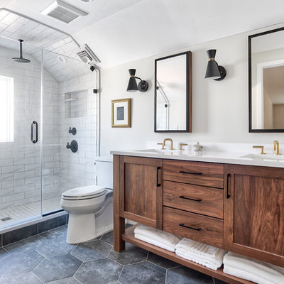 Example of a mid-sized transitional master white tile porcelain tile and black floor alcove shower design in New York with shaker cabinets, medium tone wood cabinets, a two-piece toilet, beige walls, an undermount sink, quartzite countertops, a hinged shower door and white countertops