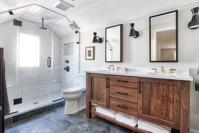 Example of a mid-sized transitional master white tile porcelain tile and black floor alcove shower design in New York with shaker cabinets, medium tone wood cabinets, a two-piece toilet, beige walls, an undermount sink, quartzite countertops, a hinged shower door and white countertops