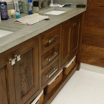 Walnut vanity with concrete top and walnut accent wall
