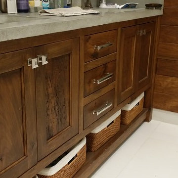 Walnut vanity with concrete top and walnut accent wall