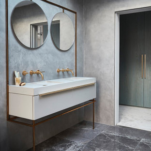 Modern bathroom in London with flat-panel cabinets, white cabinets, grey walls, an integrated sink, grey floors and white worktops.
