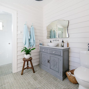 Design ideas for a shabby-chic style 3/4 bathroom in Wollongong with furniture-like cabinets, grey cabinets, a curbless shower, a two-piece toilet, white walls, a vessel sink, multi-coloured floor, a hinged shower door and grey benchtops.