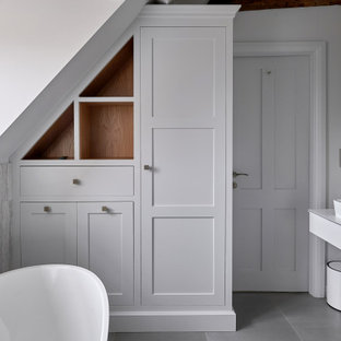 Inspiration for a small classic ensuite bathroom in West Midlands with white cabinets, a freestanding bath, grey tiles, white walls, a vessel sink, grey floors, white worktops, a single sink and a floating vanity unit.