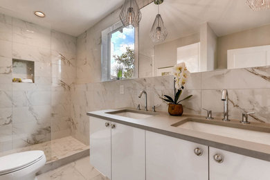 Photo of a small traditional ensuite bathroom in Denver with flat-panel cabinets, white cabinets, a walk-in shower, white tiles, porcelain tiles, porcelain flooring, a submerged sink, engineered stone worktops, white floors and an open shower.