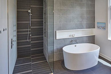 Ejemplo de cuarto de baño principal contemporáneo de tamaño medio con bañera exenta, ducha a ras de suelo y baldosas y/o azulejos grises