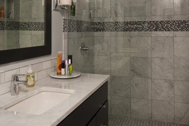 Inredning av ett modernt mellanstort en-suite badrum, med släta luckor, svarta skåp, en kantlös dusch, en toalettstol med hel cisternkåpa, vit kakel, keramikplattor, grå väggar, marmorgolv, ett undermonterad handfat och bänkskiva i kvartsit