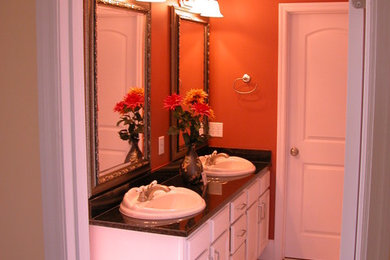 Bathroom - mid-sized mediterranean master ceramic tile and beige floor bathroom idea in Birmingham with raised-panel cabinets, white cabinets, red walls, a drop-in sink and granite countertops