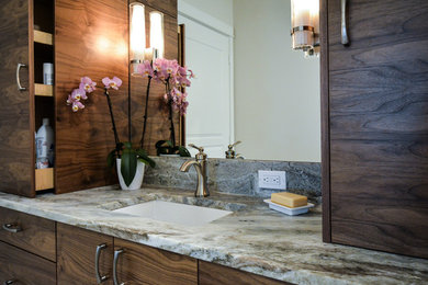 Modelo de cuarto de baño principal actual de tamaño medio con armarios con paneles lisos, puertas de armario de madera en tonos medios, encimera de cuarcita, paredes blancas y lavabo bajoencimera