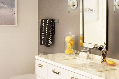 Photo of a large modern ensuite bathroom in San Francisco with flat-panel cabinets, white cabinets, a two-piece toilet, grey walls, marble flooring, a submerged sink and granite worktops.