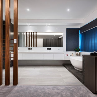 Inspiration for a modern bathroom in Perth with flat-panel cabinets, white cabinets, a freestanding tub, white walls, grey floor and white benchtops.