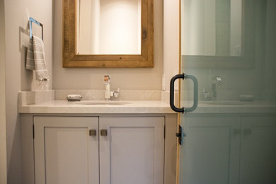 Modelo de cuarto de baño tradicional renovado con lavabo bajoencimera y paredes grises