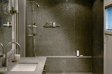 Doorless shower - mid-sized modern master black tile and glass tile doorless shower idea in Boston with flat-panel cabinets, dark wood cabinets, a one-piece toilet, an undermount sink and limestone countertops