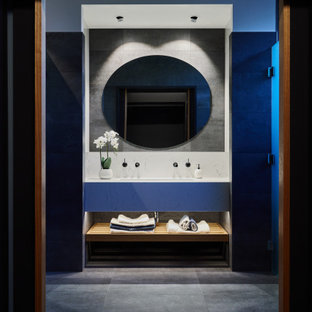 Photo of a mid-sized contemporary master bathroom in Adelaide with open cabinets, white cabinets, gray tile, a trough sink, grey floor, white benchtops, a floating vanity, a double shower, a one-piece toilet, porcelain tile, grey walls, porcelain floors, engineered quartz benchtops, a hinged shower door, an enclosed toilet and a single vanity.