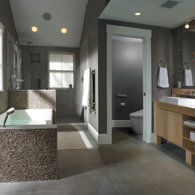 Large trendy master gray tile and cement tile bathroom photo in Boston with a vessel sink, flat-panel cabinets, light wood cabinets, gray walls, wood countertops and beige countertops